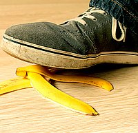 Fuß, der auf eine Bananenschale tritt und droht, auszurutschen.
