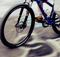 Vorderrad und Teile des Hinterrads eines Mountainbikes in schneller Fahrt