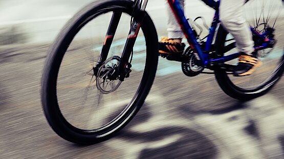 Vorderrad und Teile des Hinterrads eines Mountainbikes in schneller Fahrt