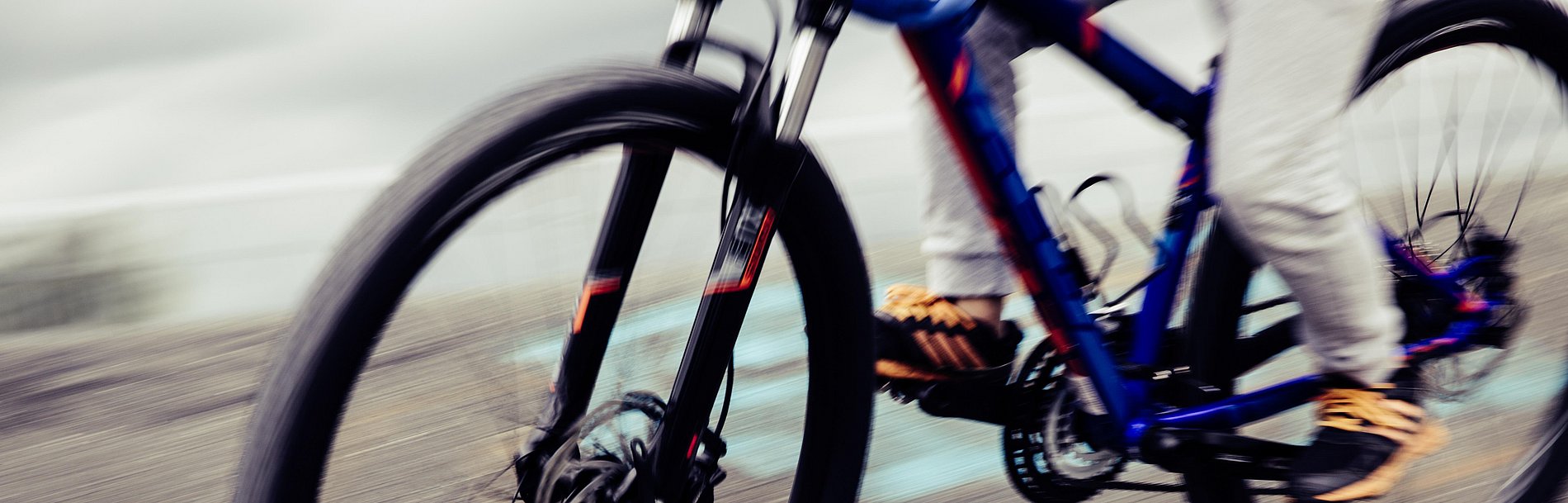 Vorderrad und Teile des Hinterrads eines Mountainbikes in schneller Fahrt